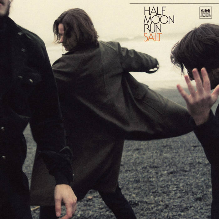 album cover shows three individuals in motion on a pebble beach and all are wearing dark clothing